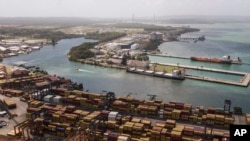 FILE - Cargo containers sit stacked as cranes load and unload containers from cargo ships at the Cristobal port, operated by the Panama Ports Company, in Colon, Panama, Feb. 4, 2025.